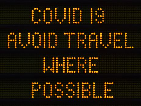 A UK Traffic Sign Warning Drivers To Avoid Travel Where Possible During The COVID-19, Or Coronavirus, Pandemic