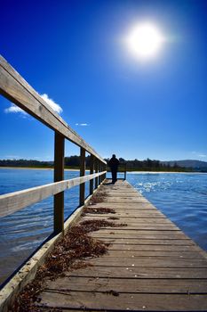 A silhouette of a person on a wharf.