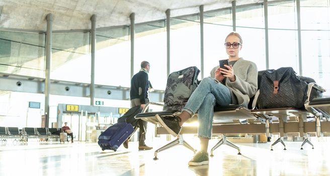 Woman stucked at airport terminal over flight cancellation writes message to family, sitting in almost empty airport terminal due to coronavirus pandemic, Covid 19, outbreak travel restrictions.