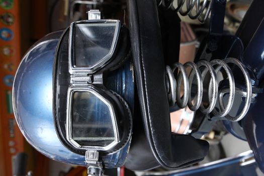 Old biker helmet and goggles in blue color