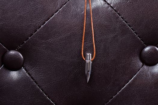 bullet lucky charm on leather couch with dark background