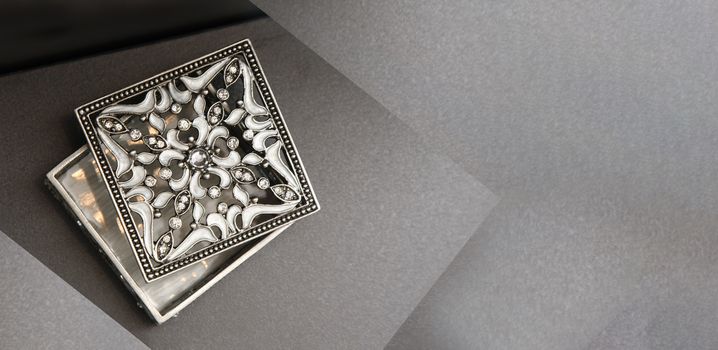 silver jewelery box on grey background with copy space