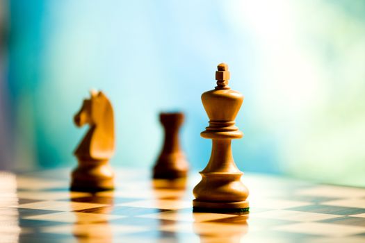 king and other players on a chess board on light blue background