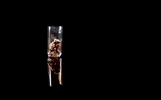 sweets in plastic food packaging with reflection and copy space on black background