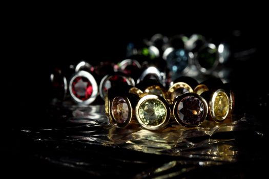 Jewelery with gem stones on tin foil black background with copy space