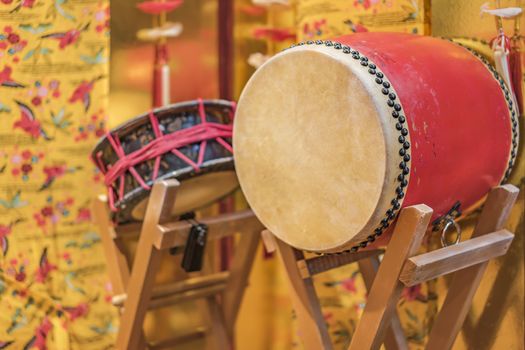 Okinawan traditional music instruments drums taiko on a concert stand with local Ryukyu Island pattern clothes on background.