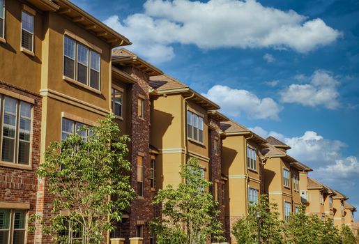 Modern Stucco and Brick Condos Under Summer Sky