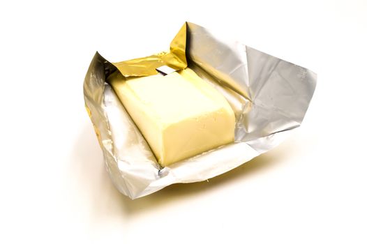 Block of rectangular fresh butter with packaging on white background