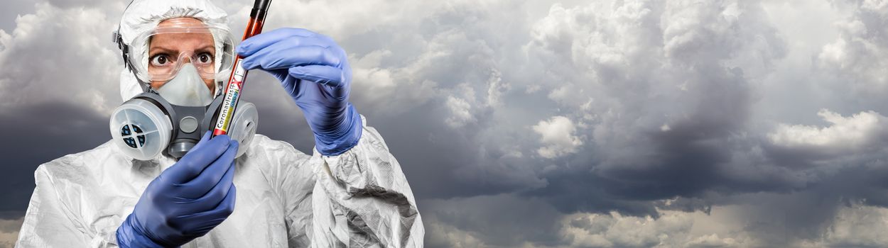 Female Doctor or Nurse In Hazmat Gear Holding Positive Coronavirus Test Tube Cloudy Sky Banner.