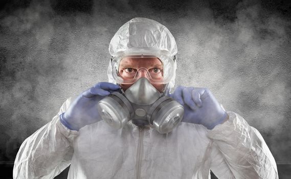 Man Wearing Hazmat Suit, Goggles and Gas Mask Is Smokey Dark Room.