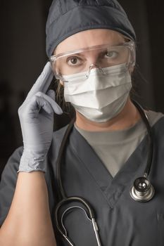 Female Doctor or Nurse Wearing Scrubs, Protective Face Mask and Goggles.