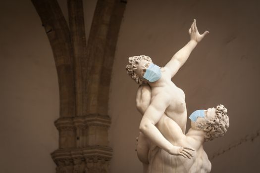 The Kidnapping of the Sabine Women Statue by Giambologna, in the Loggia dei Lanzi in Florence Italy With Face Masks - Coronavirus Scare.