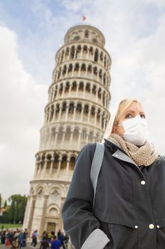 Young Woman Wearing Face Mask Walks Near The Leaning Tower of Pisa In Italy.