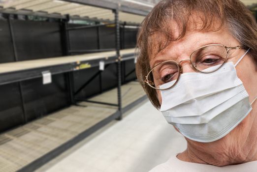 Senior Adult Woman In Medical Face Mask Walking Down Empty Aisle of Grocery Store.