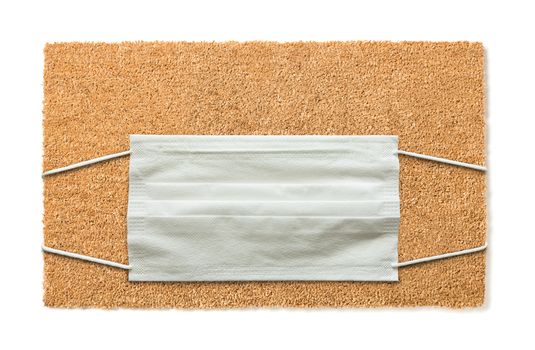 Blank Welcome Mat With Medical Face Mask Isolated on White Amidst The Coronavirus Pandemic.