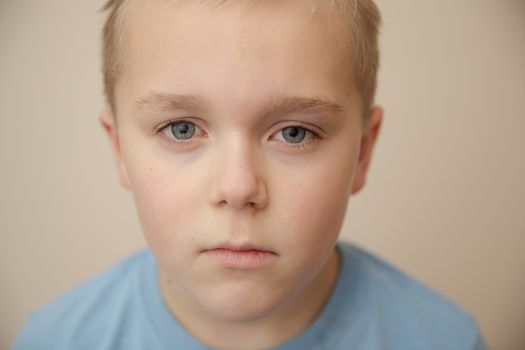 Tired or sad young boy looking at the camera