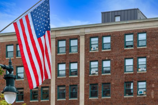 An American flag with an old red brick building in the background