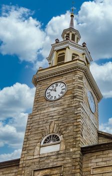 An old stone clock tower in Portland, Maine under cloudy skies