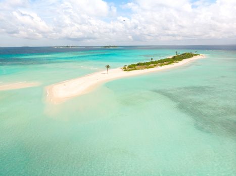 Picture perfect beach and turquoise lagoon on small tropical island on Maldives.