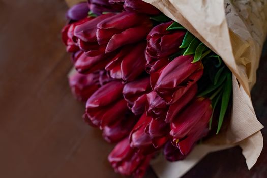Deep red tulip bouquet on wooden background