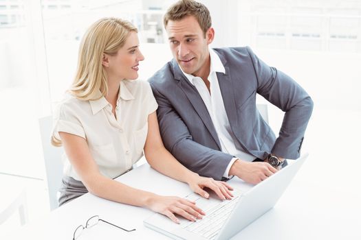 Young business people using laptop in the office