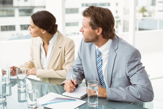 Two young business people in board room meeting at office