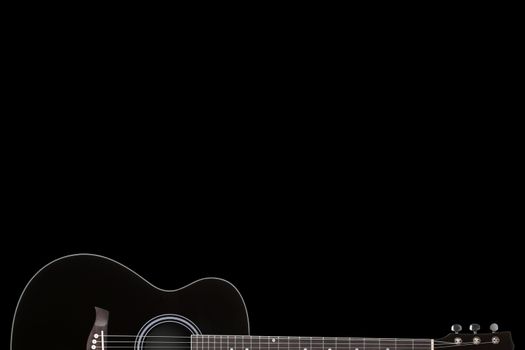 A black guitar on black background with copy space