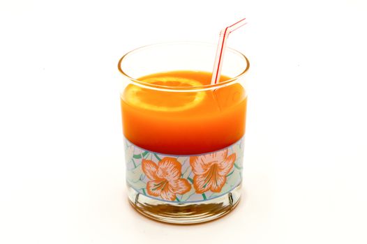 Multifruit juice in a glass with a straw on a white background