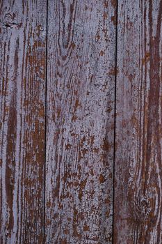Old red wooden texured door surface closeup. Relief on surface. Stock photo of old wooden door pattern of aged boards with scratches. Red and gray colors on photo.