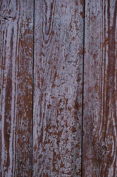 Old red wooden texured door surface closeup. Relief on surface. Stock photo of old wooden door pattern of aged boards with scratches. Red and gray colors on photo.