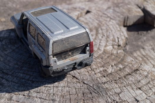 A silver toy car on wooden background. This is jeep offroad SUV made in metal