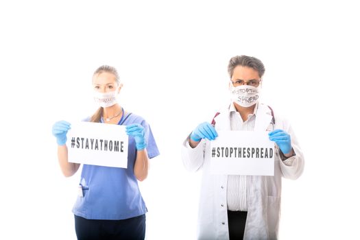 Doctors and medical staff hold a sign to warn the community to stop the spread of the contagious virus called COVID-19 or Coronavirus.  A pandemic that started in Wuhan China