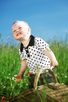 Picnic on green grass boy and basket summer sunny day