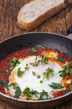 shakshuka in a pan on dark wood