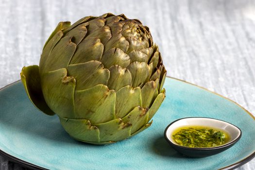 cooked artichoke on a blue plate