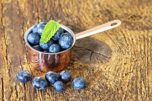 blue berries in a pot on wood