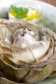 cooked artichoke on a green plate