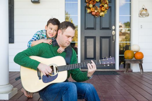 Young Mixed Race Chinese and Caucasian Son Singing Songs and Playing Guitar with Father