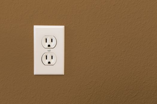 Electrical Sockets In Colorful Brown Wall of House.