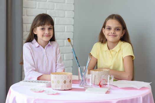 Children sit at the table and prepare for the celebration of Easter