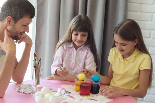 Children painted the first Easter eggs, dad watches them