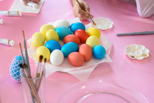 Coloring Easter eggs, multi-colored eggs in the middle of the table