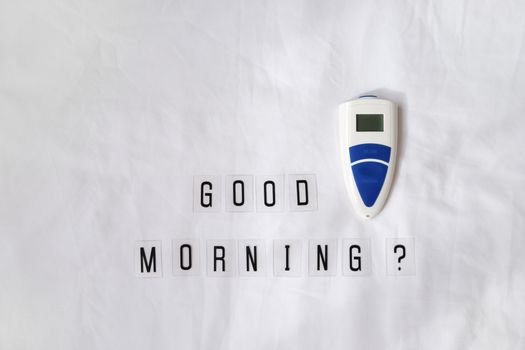 Inscription question Good morning, thermometer on crumpled white sheet. Awakening concept with headache, fever, medicine, illness, health, migraine. Horizontal, flat lay.