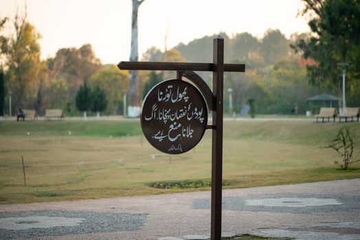 Caution written in Urdu on Sign board, Plucking the flowers and damaging the plants is prohibited, Fire is not allowed