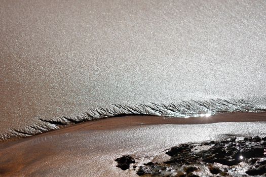 A close up of a stream near rocks at the beach.