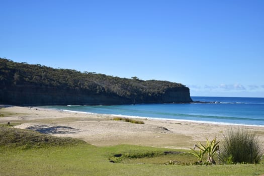 A beach with cliffs and mountains