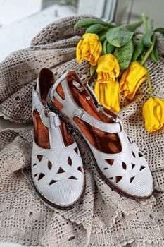 Different shoes with accessories on a studio background