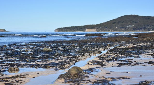 Seascape from the rocks with a line leading towards a mountain