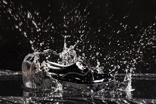 Shoe falling into the water on a studio background