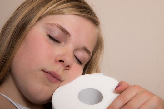 Young girl happy that she has toilet paper and hugs it